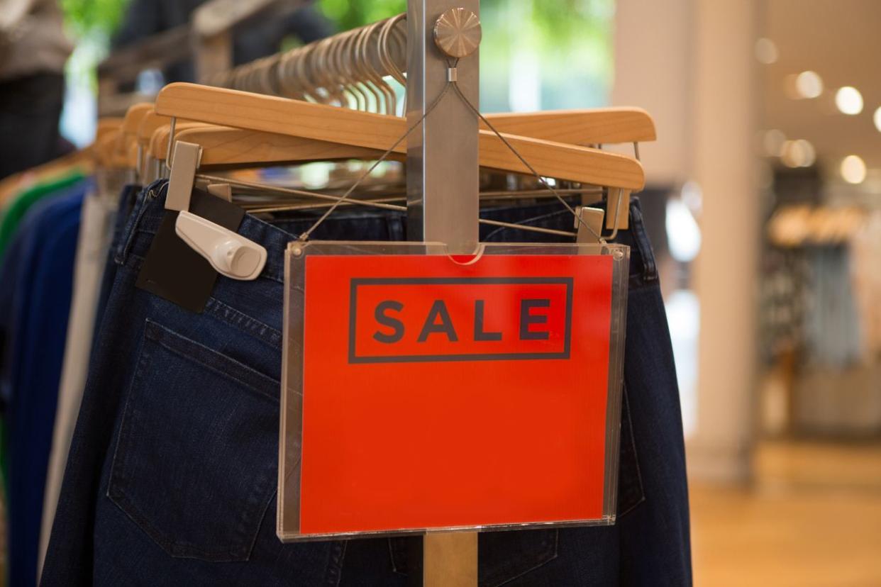 Sale sign in store on clothing rack