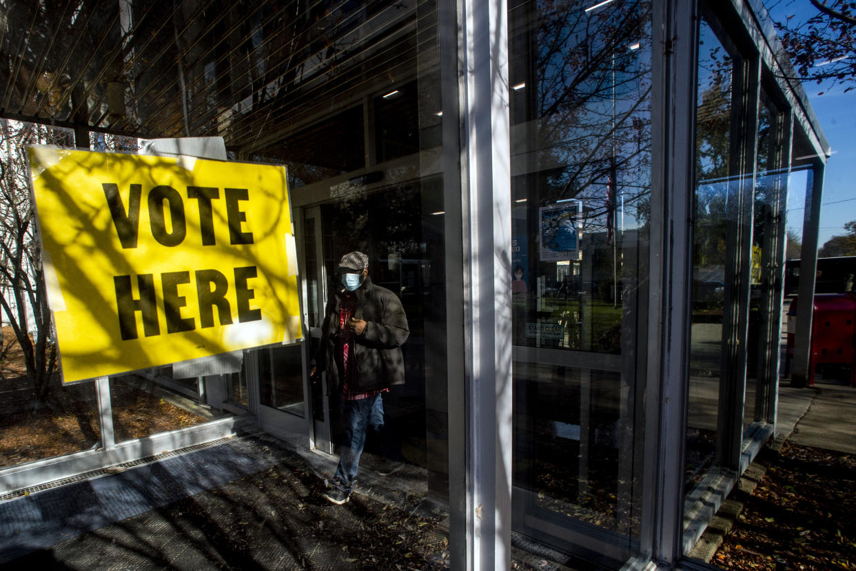 FILE - In this Nov. 3, 2020 file photo, Delano Mathis runs back to his house to get his identification before voting on Election Day in Flint, Mich. Republicans who control the Michigan Senate passed legislation Wednesday, June 16, 2021, that would mandate a photo ID to vote in-person and add identity requirements for people who want to vote by mail. (Jake May/The Flint Journal via AP, File)