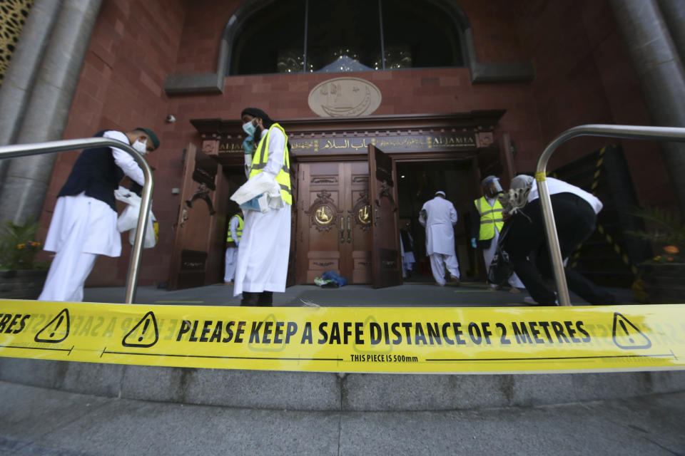 Muslim men arrive at the Bradford Grand Mosque for Eid al-Adha prayers, in Bradford, West Yorkshire, England, Friday July 31, 2020. Britain’s health secretary has defended a decision to reimpose restrictions on social life in a swath of northern England, saying it was important to keep ahead of the spread of COVID-19. The affected region has a large Muslim population, and the restrictions come prior to the Eid al-Adha holiday starting on Friday. (Danny Lawson/PA via AP)