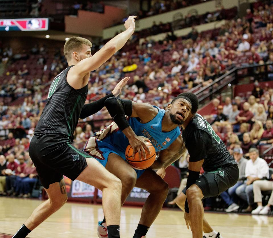 Florida State Seminoles forward Malik Osborne (10) struggles to keep possession of the ball with two defenders covering him. The Florida State Seminoles narrowly defeated the Tulane Green Wave 59-54 Wednesday, Nov. 17, 2021.