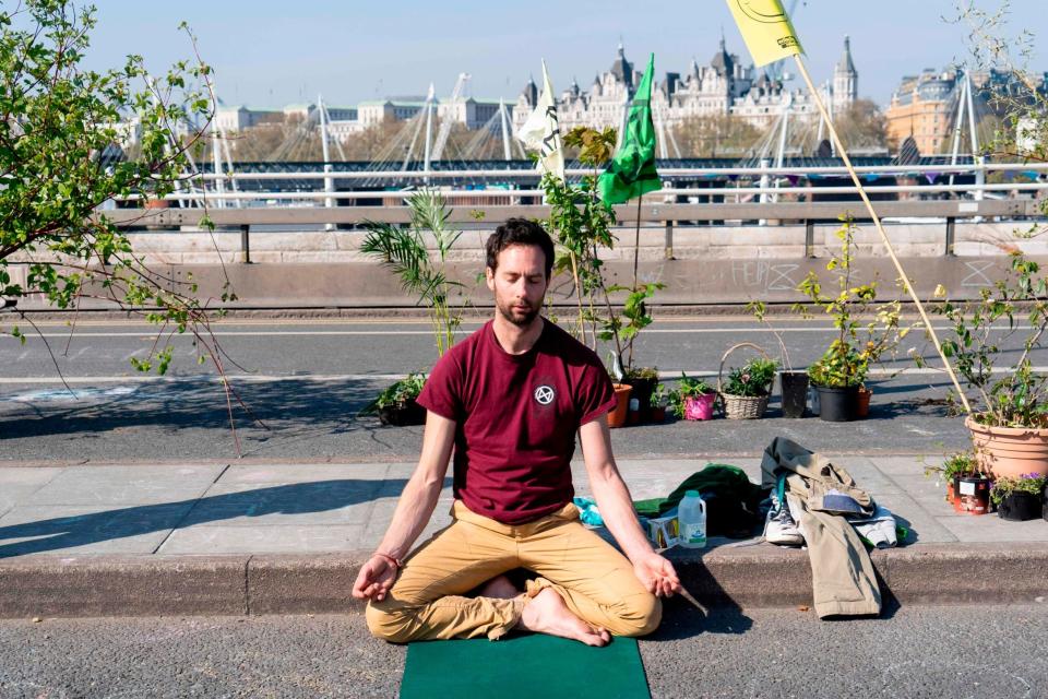 A climate change activist meditates as demonstrators continue to block Waterloo Bridge (AFP/Getty Images)