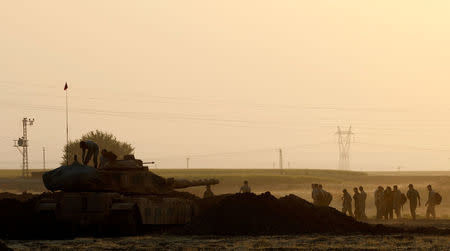 Turkish soldiers walk past a tank during a military exercise near the Turkish-Iraqi border in Silopi, Turkey, September 22, 2017. REUTERS/Umit Bektas