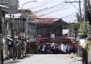 Residents believed to be hostages and used as human shields of Moro National Liberation Front rebels wave white cloth and shout to the government soldiers to "stop firing" while standing in the rebels' positions in downtown Zamboanga city, in southern Philippines September 11, 2013. REUTERS/Erik De Castro