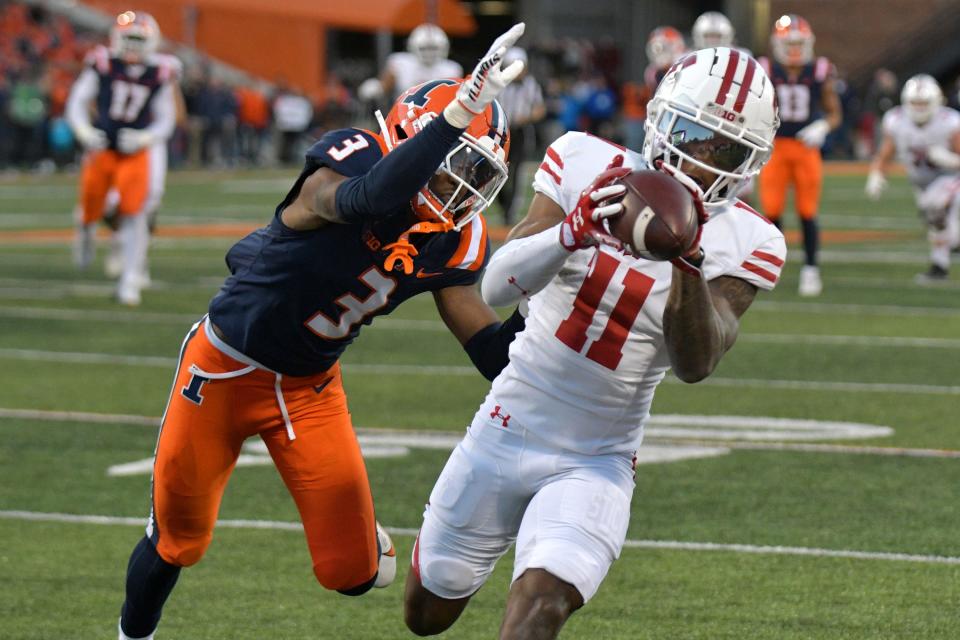 Oct 21, 2023; Champaign, Illinois, USA; Wisconsin Badgers wide receiver Skyler Bell (11) catches a pass in front of Illinois Fighting Illini defensive back Tahveon Nicholson (3) during the second half at Memorial Stadium. Mandatory Credit: Ron Johnson-USA TODAY Sports