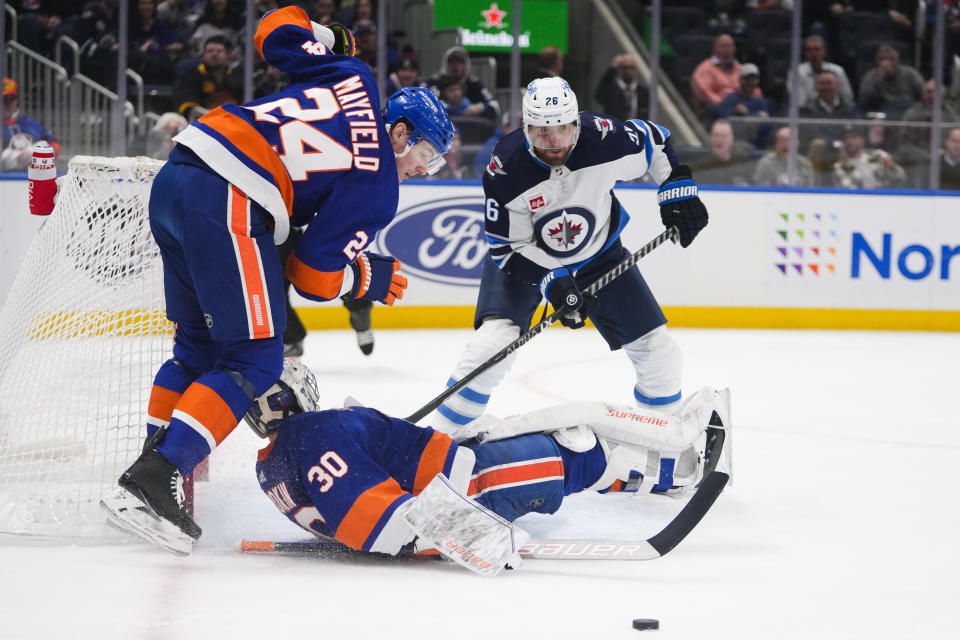 New York Islanders' Scott Mayfield (24) and goaltender Ilya Sorokin (30) protect their net from Winnipeg Jets' Blake Wheeler (26) during the first period of an NHL hockey game Wednesday, Feb. 22, 2023, in Elmont, N.Y. (AP Photo/Frank Franklin II)