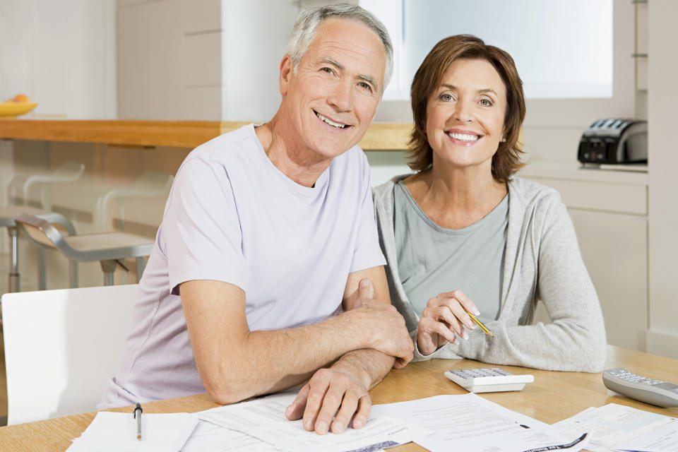 Older couple at table with calculator and papers in front of them