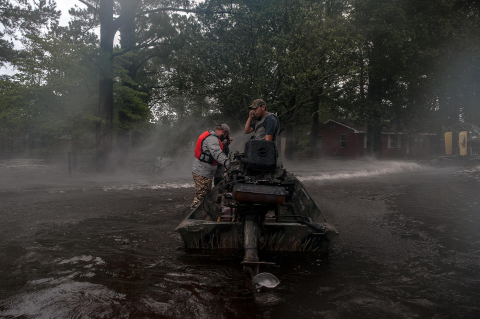 Rescuers with the Cajun Navy shield their faces from the spray off a fan boat as they prepare to enter a flooded neighborhood to evacuate people still in their homes in Lumberton on Sunday.