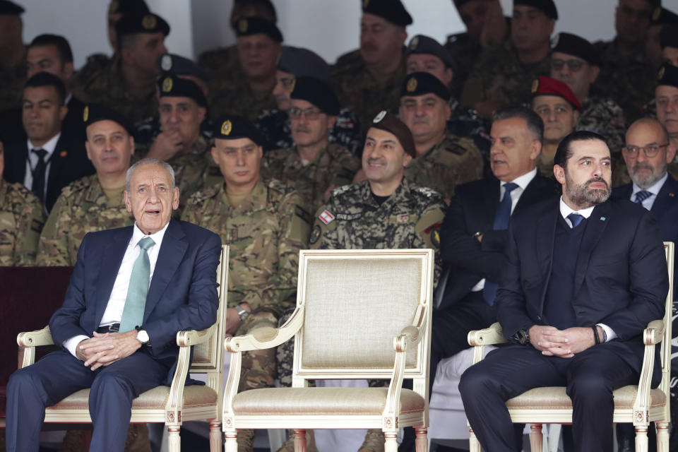 Lebanese Parliament Speaker Nabih Berri, left, and resigned Lebanese Prime Minister Saad Hariri attend a military parade to mark the 76th anniversary of Lebanon's independence from France at the Lebanese Defense Ministry, in Yarzeh near Beirut, Lebanon, Friday, Nov. 22, 2019. Lebanon's top politicians Friday attended a military parade on the country's 76th Independence Day, appearing for the first time since the government resigned amid nationwide protests now in their second month. (AP Photo/Hassan Ammar)