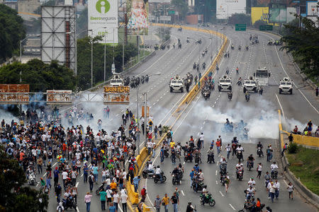 Demonstrators run away from tear gas during clashes with police while rallying against Venezuela's President Nicolas Maduro in Caracas, Venezuela, April 20, 2017. REUTERS/Christian Veron