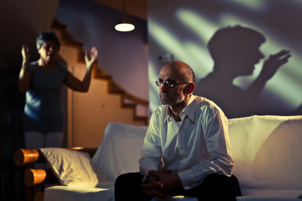 man watching tv while woman screams in background