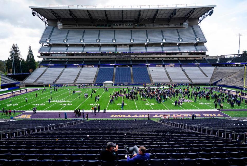 University of Washington Huskies fans and players gather on the field after the spring game at Husky Stadium in Seattle on April 30, 2022.