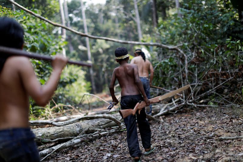 FILE PHOTO: Indigenous Mura people walk in a deforested area of a non-demarcated indigenous land in the Amazon rainforest near Humaita