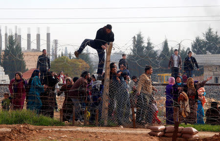 FILE PHOTO: Syrians try to cross the border from the Syrian town of Ras al-Ain to the Turkish border town of Ceylanpinar after an air strike December 3, 2012. REUTERS/Laszlo Balogh/File Photo