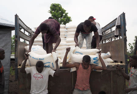 Volunteers unload maize meal supplied by the United Nations Food Program at the Lovua refugee camp in Angola, September 13, 2017. REUTERS/Stephen Eisenhammer/Staff