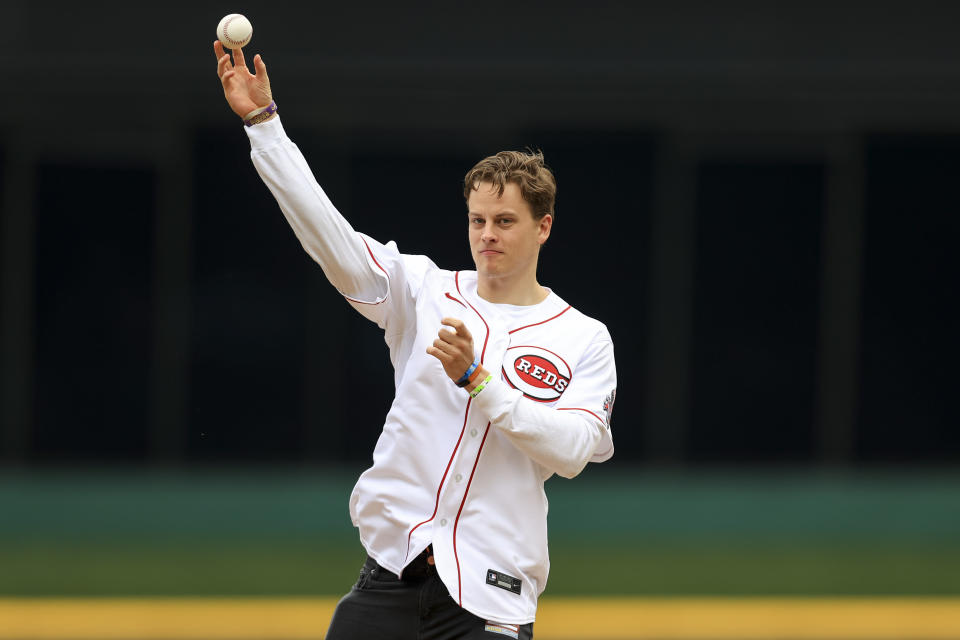 Cincinnati Bengals' Joe Burrow throws out the ceremonial first pitch prior to a baseball game between the Cleveland Guardians and the Cincinnati Reds in Cincinnati, Tuesday, April 12, 2022. (AP Photo/Aaron Doster)