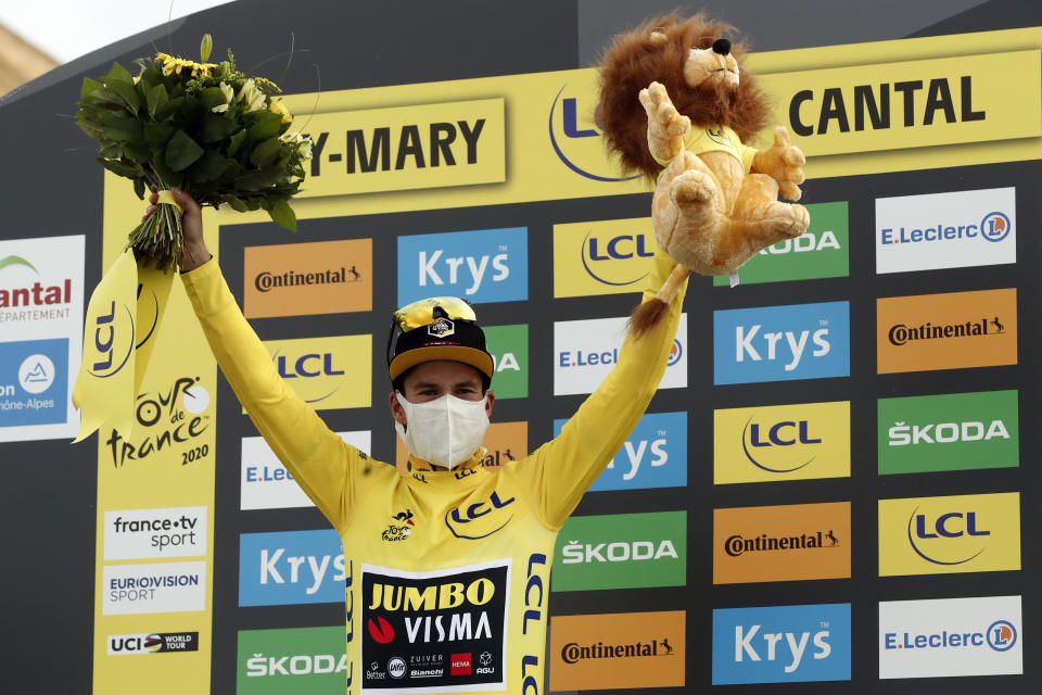 Slovenia's Primoz Roglic wearing the overall leader's yellow jersey celebrates in the podium after the stage 13 of the Tour de France cycling race over 191 kilometers from Chatel-Guyon to Puy Mary, Friday, Sept. 11, 2020. (Benoit Tessier, Pool via AP)