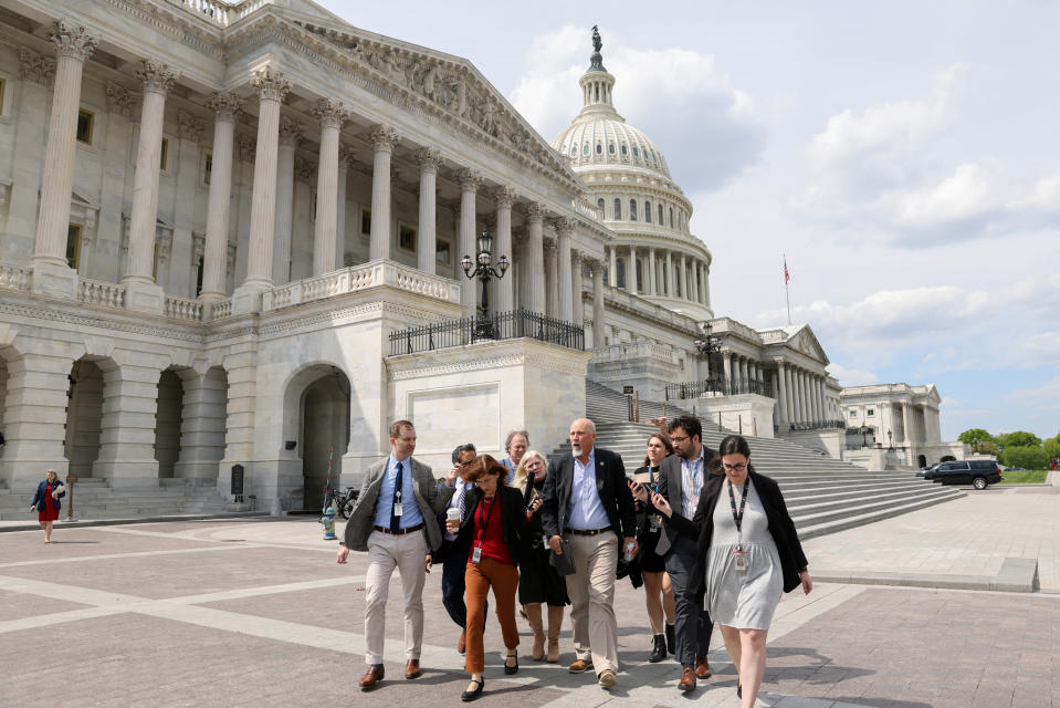 Rep. Chip Roy walks in front of the Capitol surrounded by a posse of reporters.