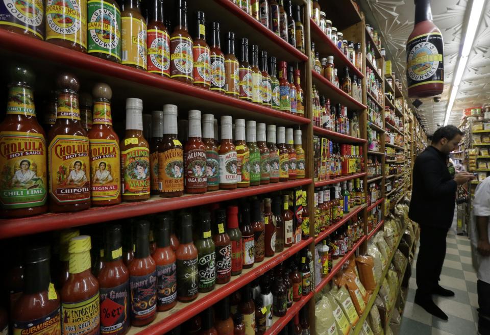 In this Nov. 21, 2013 photo, bottled hot sauces, roughly 250 varieties, fill a section of Kalustyan's Indian/Middle Eastern spice and specialty food shop in New York. The not-so-little gem of a shop nestled into a row of like-minded stores on Lexington Avenue is known to New Yorker foodies, but off the map for most tourists. (AP Photo/Richard Drew)