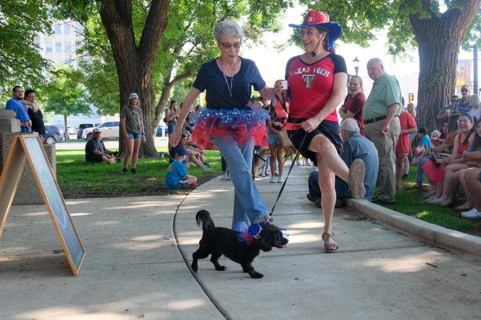 Shona Rose and Donna Burton look to give their dog Joy a leg up on the competition during the patriotic pet parade Saturday morning at the Amarillo Community Market in downtown Amarillo.