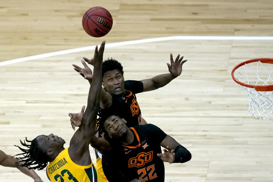 Baylor's Jonathan Tchamwa Tchatchoua battles Oklahoma State's Kalib Boone (22) and Matthew-Alexander Moncrieffe (12) for a rebound during the first half of an NCAA college basketball game in the semifinals of the Big 12 tournament in Kansas City, Mo., Friday, March 12, 2021. (AP Photo/Charlie Riedel)