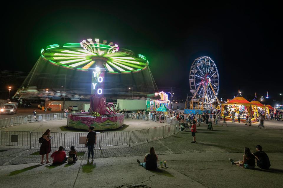 Fairgoers watch as children ride the "Yo Yo" and Ferris wheel in the kiddie ride section at the Colorado State Fair on Saturday, September 2, 2023.