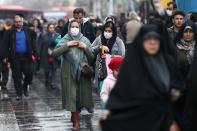 Iranian women wear protective masks to prevent contracting a coronavirus, as they walk at Grand Bazaar in Tehran