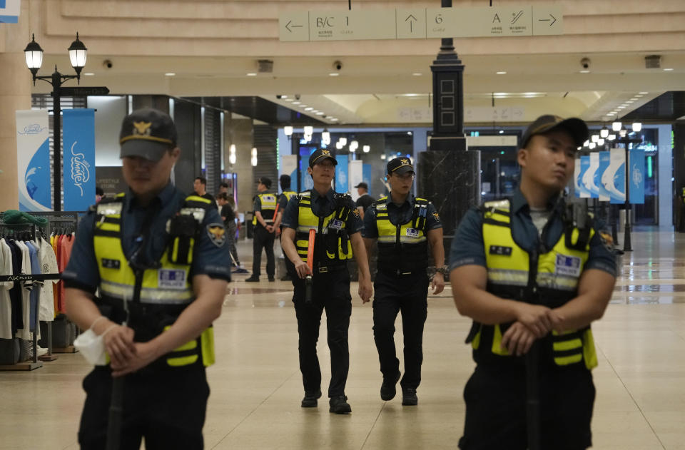 Police officers patrol at the scene near a subway station in Seongnam, South Korea, Thursday, Aug. 3, 2023. A dozen of people were injured in South Korea on Thursday when a man rammed a car onto a sidewalk and then stepped out of the vehicle and began stabbing people near a subway station in the city of Seongnam. (AP Photo/Ahn Young-joon)