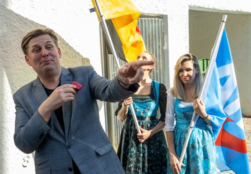 Maximilian Krah, lead candidate of the Alternative for Germany (AfD) for the European elections, gestures next to two women on the sidelines of an election campaign event in Holzkirchen. Stefan Puchner/dpa