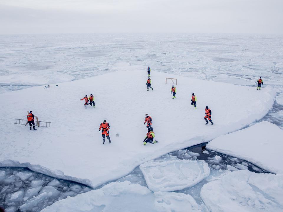 FILE PHOTO: KV Svalbard's crew, formed by Norwegian Navy privates and scientists from Norwegian Institute of Marine Research, play soccer as they are protected from polar bears by armed guards in the arctic environment in the sea around Greenland, March 22, 2018. Marius Vagenes Villanger/Kystvakten/Sjoforsvaret/NTB Scanpix via REUTERS