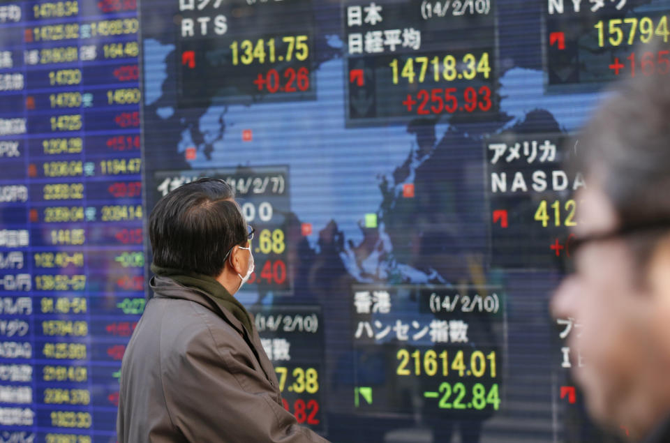 A man looks at an electronic stock indicator showing global stock prices including Japan's benchmark Nikkei 225, top center, which gained 255.93 points, or 1.77 percent, and closed at 14,718.34 in Tokyo Monday, Feb. 10, 2014. Asian stock markets were mostly higher Monday as investors looked ahead to Janet Yellen's first comments before Congress as the new Federal Reserve chairwoman. (AP Photo/Shizuo Kambayashi) (AP Photo/Shizuo Kambayashi)