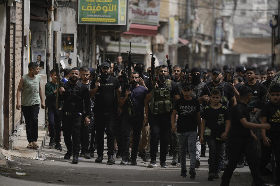 Palestinian gunmen march during the funeral of three Palestinian militants, Abdullah Abu Hamdan, 24, Muhammad Zaytoun, 32, and Fathi Rizk, 30, in the Balata refugee camp near the West Bank town of Nablus Monday, May 22, 2023. The Israeli military raided the camp early Monday, sparking a firefight that killed the three militants. (AP Photo/Majdi Mohammed)