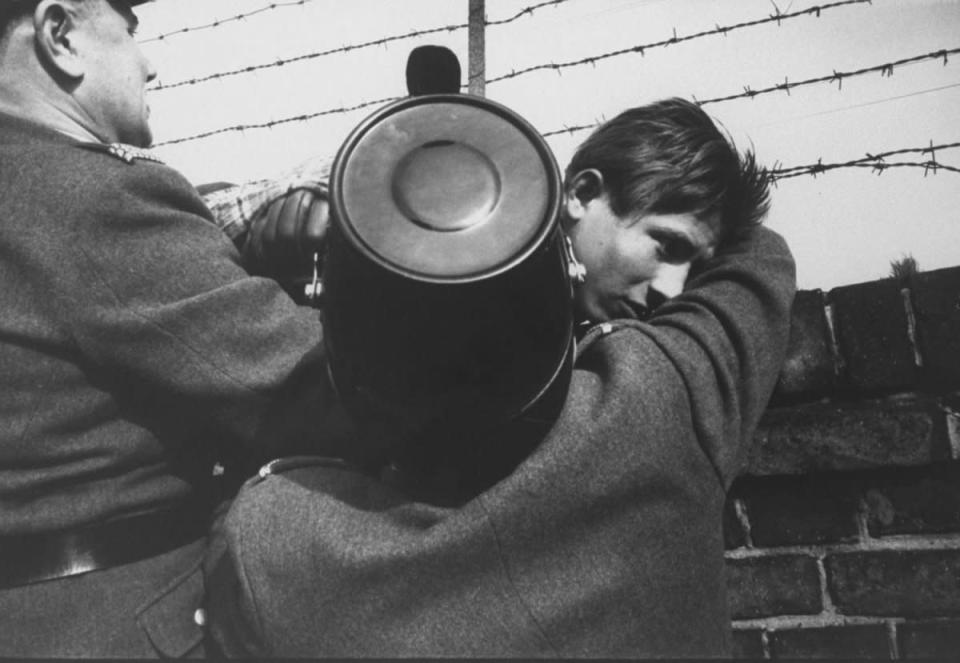 A 17-year-old East German orphan successfully slips through the barbed wire over the Berlin Wall to the West after being waved on by West Berlin police in October 1961. "This boy," wrote LIFE, "a 17-year-old orphan, was too dazed to say anything but 'Thanks, thanks,' as he shook the hands that had helped him." (Paul Schutzer—Time & Life Pictures/Getty Images) <br> <br> <a href="http://life.time.com/history/berlin-wall-photos-early-days-of-the-cold-war/#1" rel="nofollow noopener" target="_blank" data-ylk="slk:Click here to see the full collection at LIFE.com;elm:context_link;itc:0;sec:content-canvas" class="link ">Click here to see the full collection at LIFE.com</a>