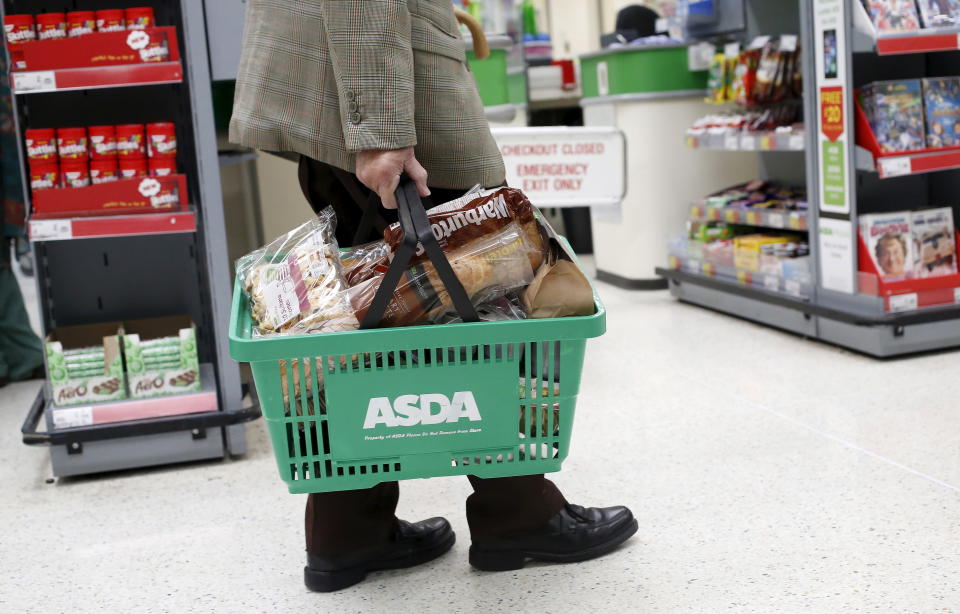 A man carries a shopping basket in an Asda store in northwest London, Britain in this August 18, 2015 file photo. Asda is expected to report Q3 results this week.   REUTERS/Suzanne Plunkett/FilesGLOBAL BUSINESS WEEK AHEAD PACKAGE - SEARCH "BUSINESS WEEK AHEAD NOV 16" FOR ALL IMAGES