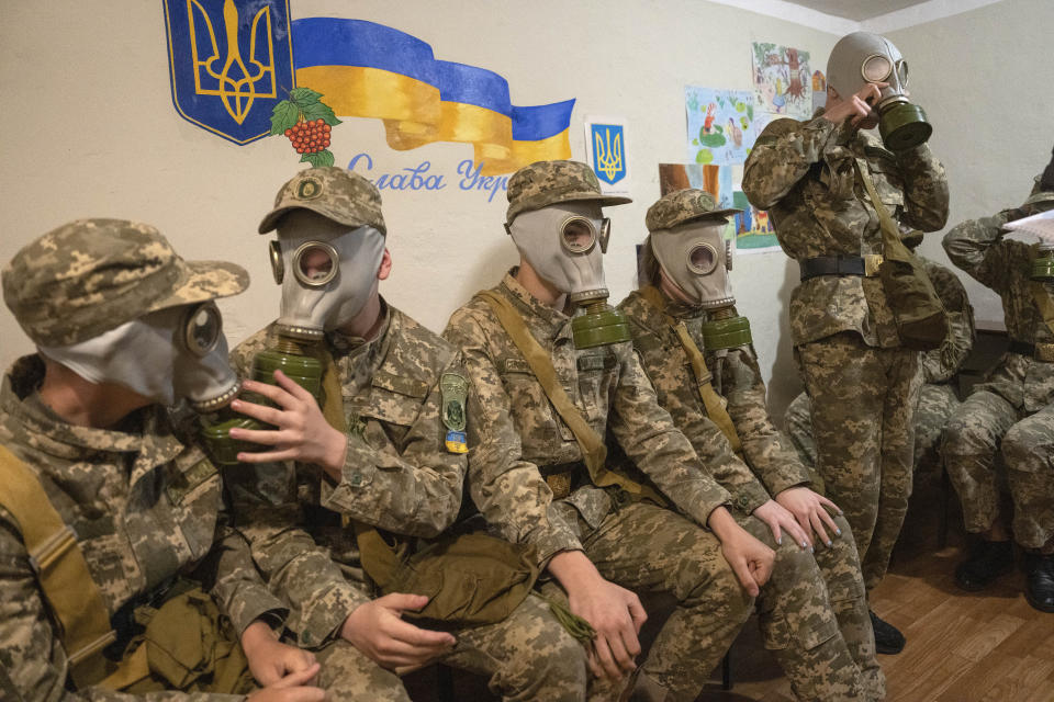 Cadetes ensayan cómo colocarse las máscaras antigás en un refugio antibombas, en Kiev, Ucrania, el 6 de junio de 2023. (AP Foto/Efrem Lukatsky)