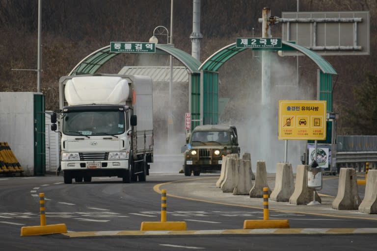 Vehicles leaving Kaesong pass through disinfectant spray before a checkpoint near the Demilitarized Zone in Paju on February 11, 2016