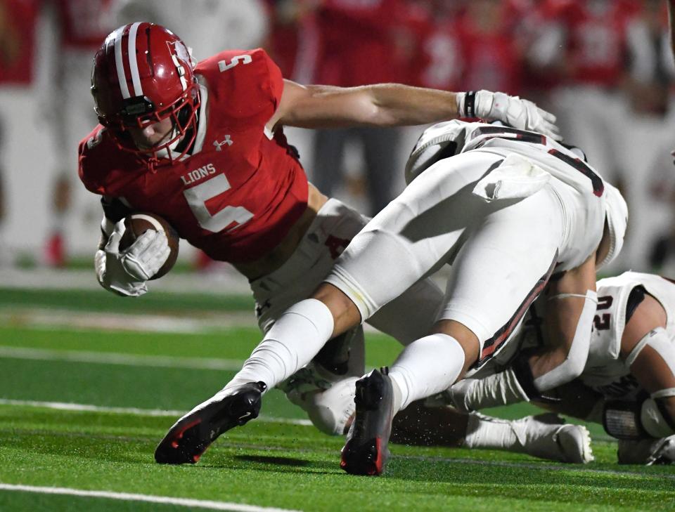 Albany's Adam Hill, left, runs with the ball against New Home in the Class 2A Division II state semifinal football game at the Mustang Bowl in Sweetwater. Hill scored twice as the Lions earned a trip to Arlington with a 53-25 win.