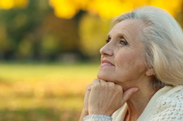 Senior woman walking in the park in autumn