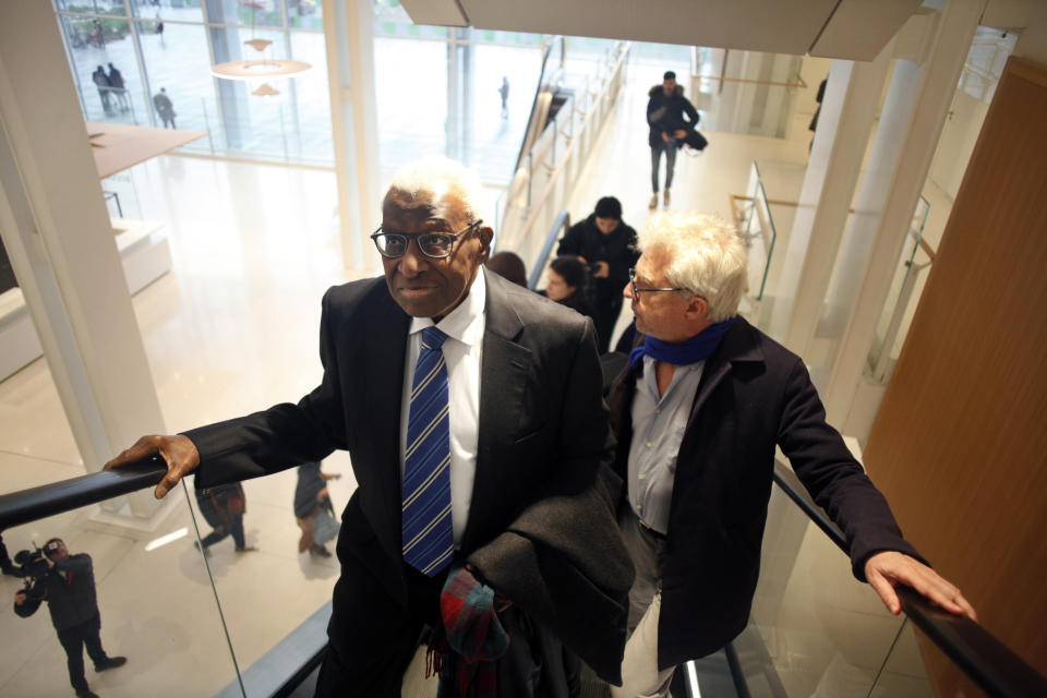 CAPTION CORRECTS SPELLING OF SURNAME Former president of the IAAF (International Association of Athletics Federations) Lamine Diack, left, arrives with his lawyer William Bourdon, right, at the Paris courthouse, Monday, Jan. 13, 2020. One of the biggest sports corruption cases to reach court is being heard in Paris from Monday, with explosive allegations of a massive doping cover-up at the top of track and field. (AP Photo/Thibault Camus)
