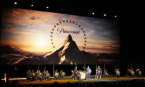 Chris Aronson, center, president of domestic theatrical distribution for Paramount Pictures, arrives via chariot to the Paramount Pictures presentation at CinemaCon 2024, Thursday, April 11, 2024, at Caesars Palace in Las Vegas. The studio is releasing "Gladiator 2" later in the year. (AP Photo/Chris Pizzello)