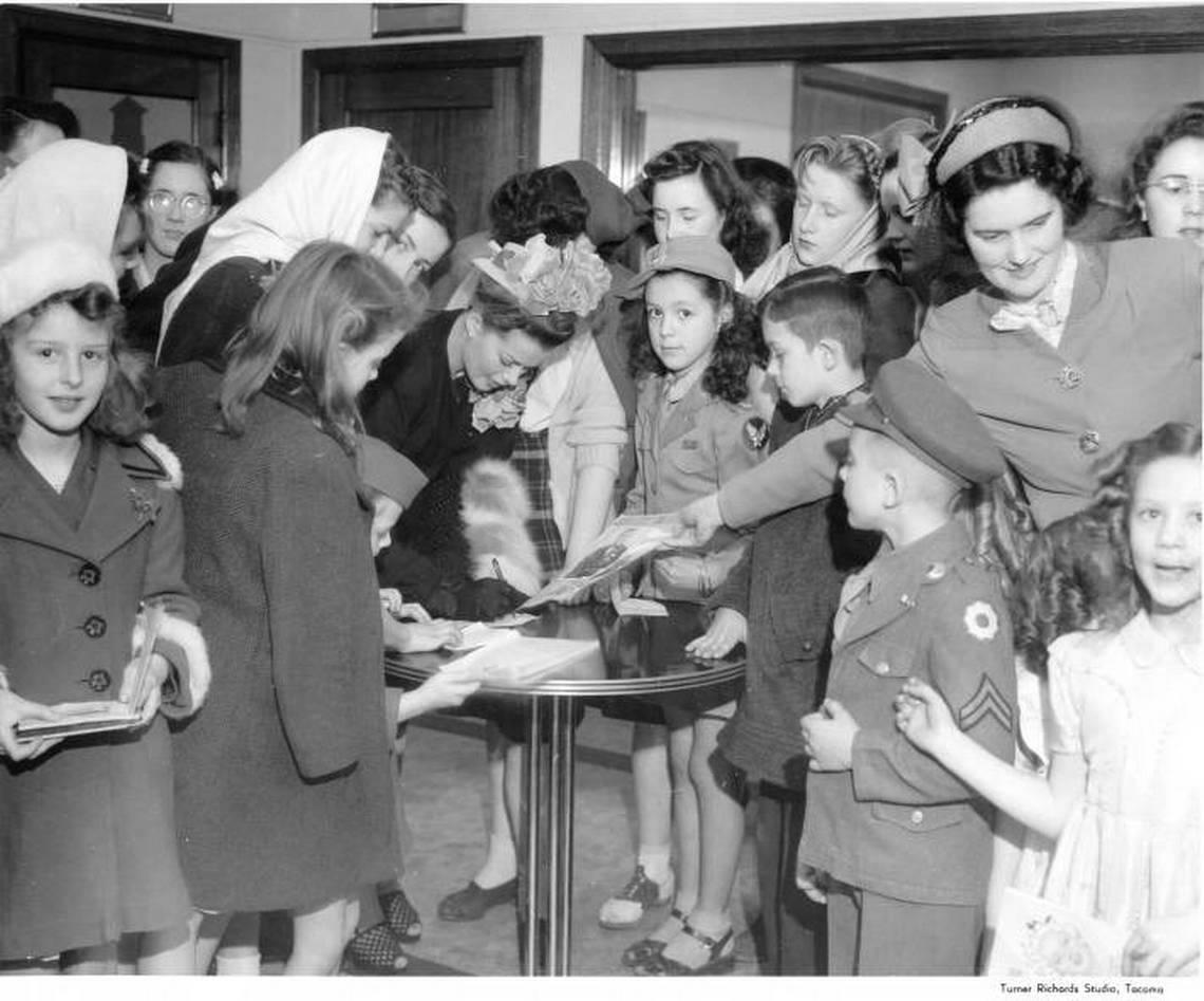 Actress Janis Paige signs autographs for children at KMO Studios in 1946. Children appear to be service dependents. Courtesy/Northwest Room at The Tacoma Public Library