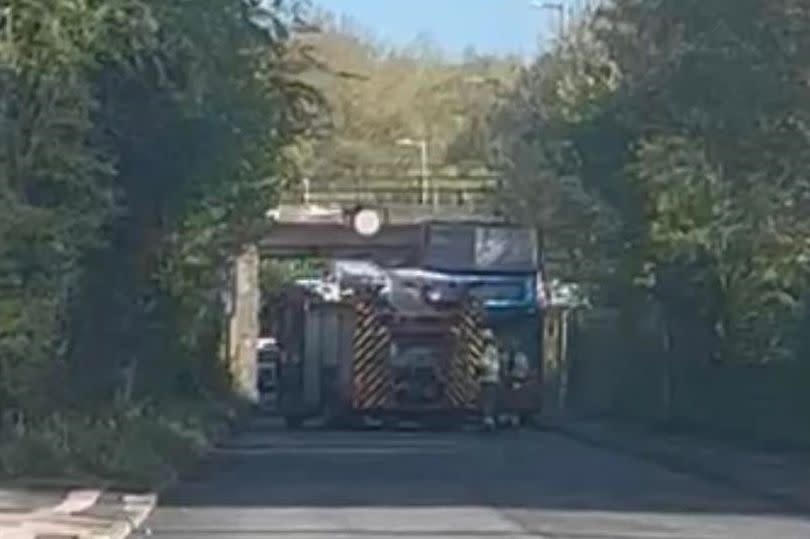 A double-decker bus has collided with a bridge in Clayhanger Lane in Walsall, with a fire engine pictured beside the bus, with the whole of the top deck taken off