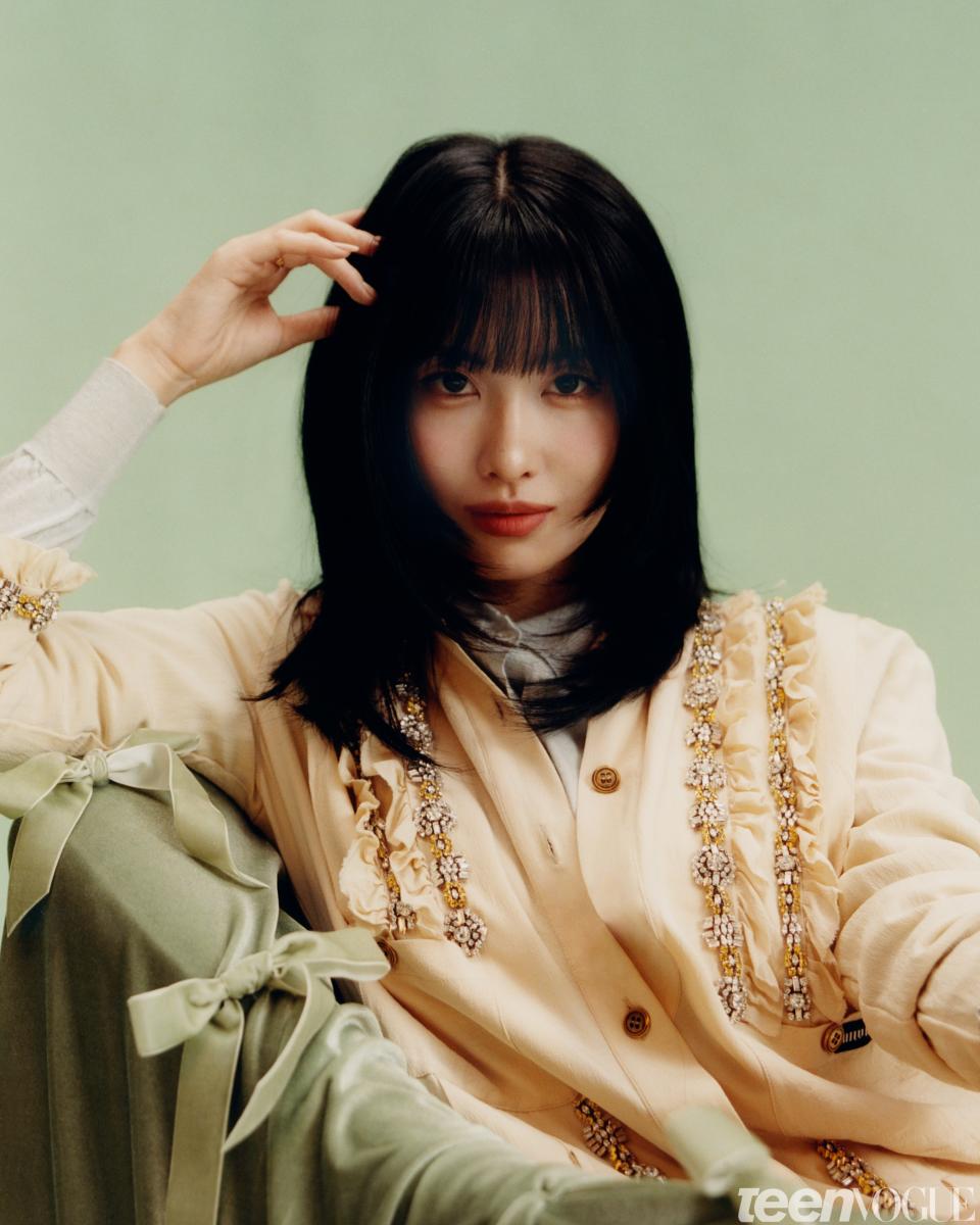 Momo wears a [Miu Miu top, cardigan, and shoes](https://www.miumiu.com/).