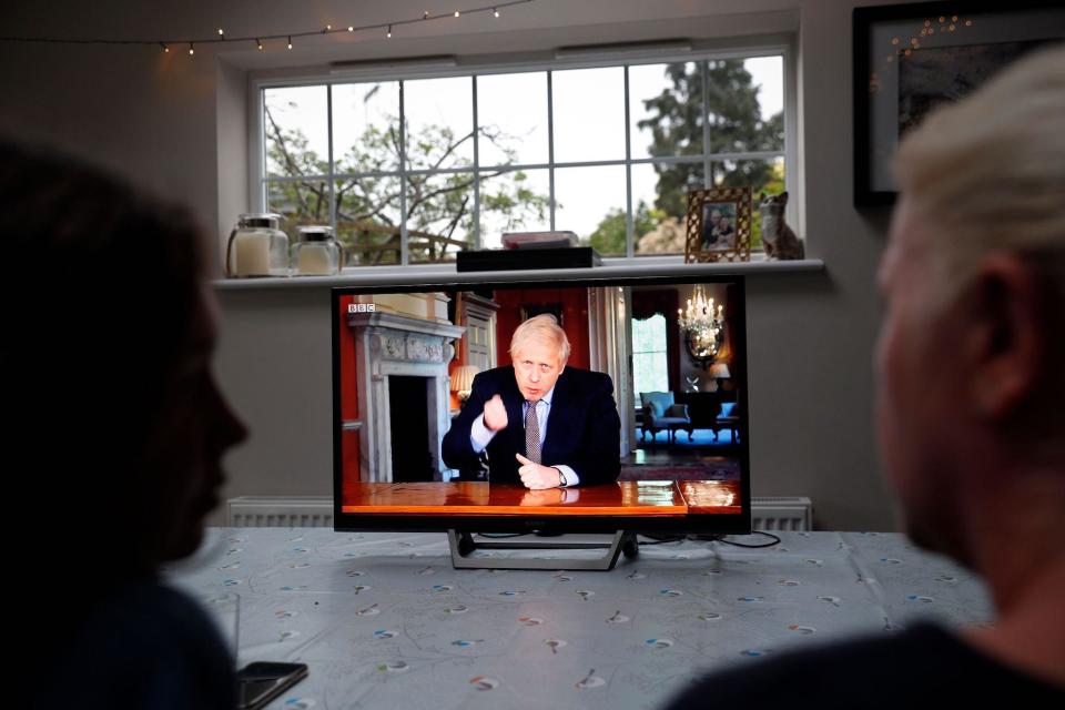 A family gather around the television to watch Britain's Prime Minister Boris Johnson give a televised message to the nation in Hartley Wintney, west of London on May 10, 2020, as the government sets out it's roadmap to ease the national lockdown due to the novel coronavirus COVID-19 pandemic: ADRIAN DENNIS/AFP via Getty Images