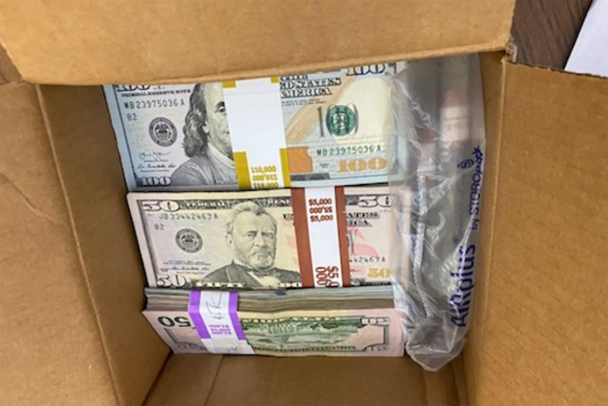 An NYPD officer snapped a photo of the box, which contained stacks of $100 and $50 bills, amounting to $180,000. / Credit: NYPD via City College of New York