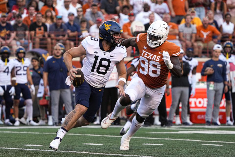 Texas defensive lineman Moro Ojomo chases West Virginia quarterback JT Daniels in the first quarter. In the first half, the Longhorns produced two sacks, four tackles for loss and six pass breakups. Ojomo had one sack.