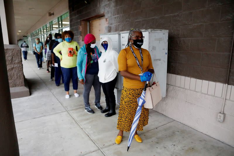 People line up at a polling station as early voting begins in Florida