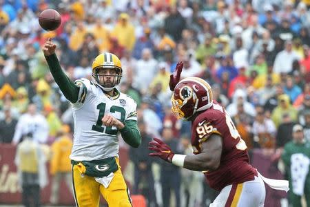 Sep 23, 2018; Landover, MD, USA; Green Bay Packers quarterback Aaron Rodgers (12) passes the ball as Washington Redskins defensive tackle Da'Ron Payne (95) defends in the third quarter at FedEx Field. The Redskins won 31-17. Mandatory Credit: Geoff Burke-USA TODAY Sports