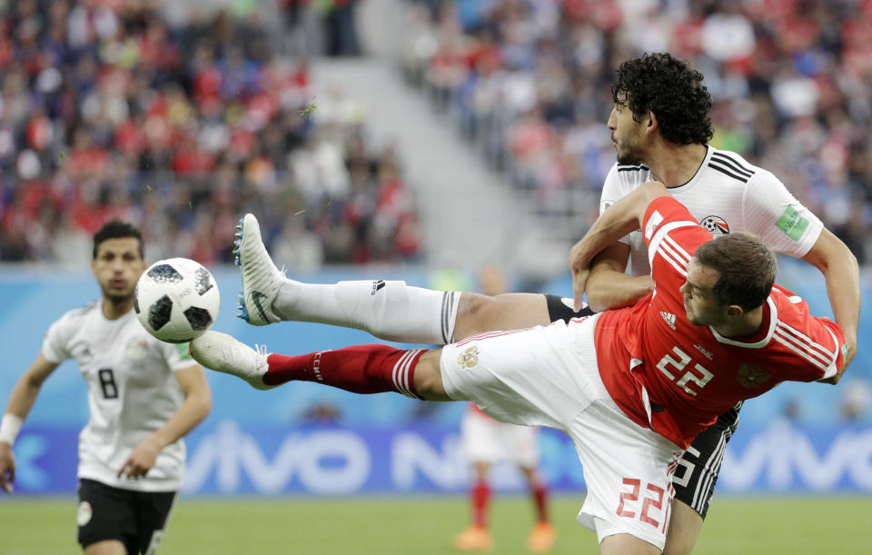 <p>Ahmed Hegazy challenges for the ball with Artyom Dzyuba </p>