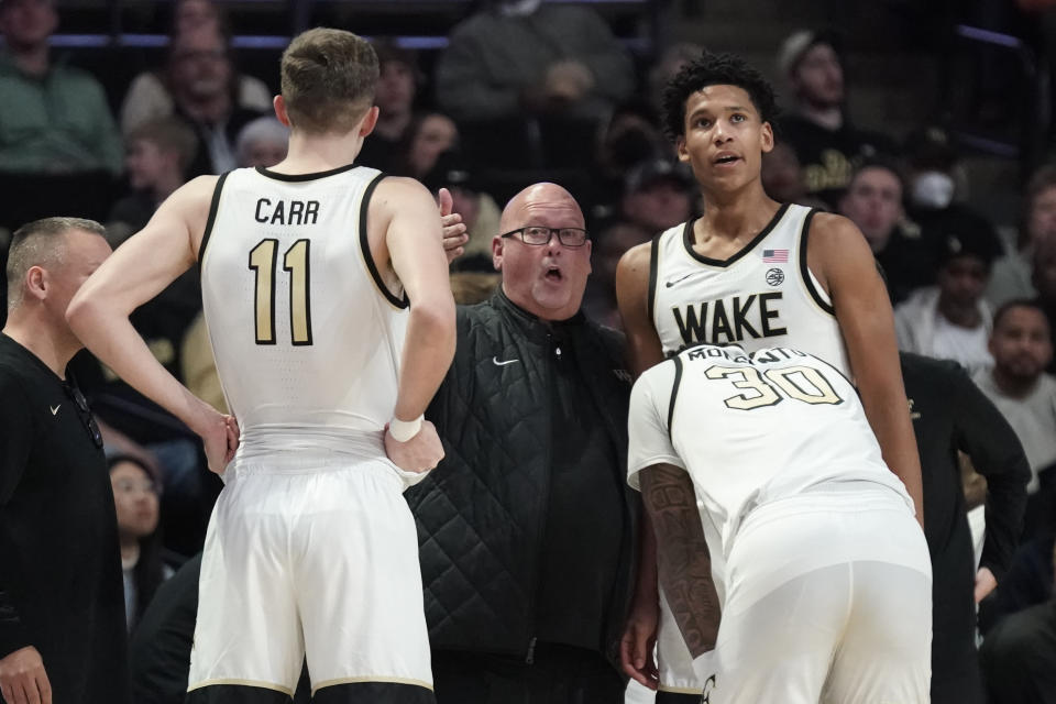 Wake Forest head coach Steve Forbes, center, talks to players during a timeout in the first half of an NCAA college basketball game against Clemson in Winston-Salem, N.C., Tuesday, Jan. 17, 2023. (AP Photo/Chuck Burton)