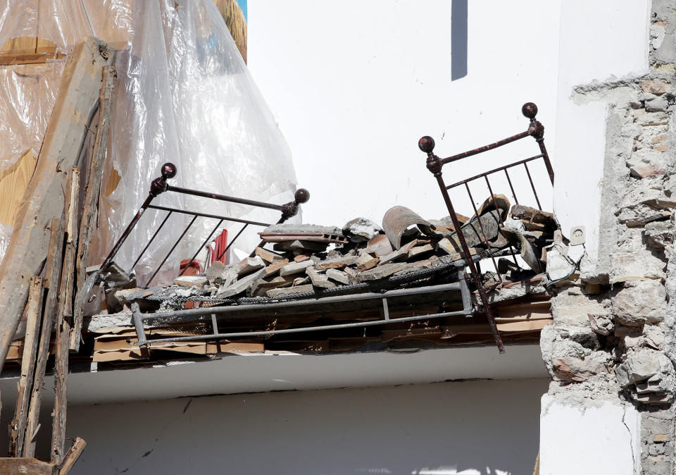 A bed is seen in a collapsed house